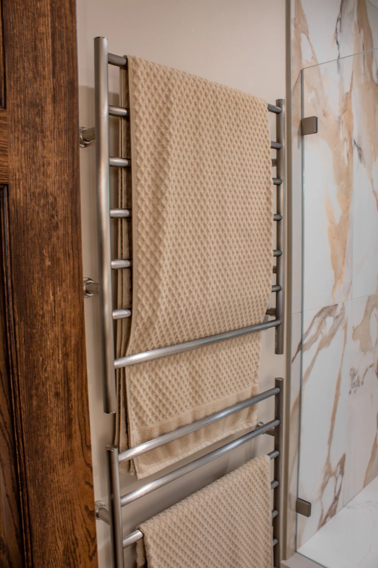 Wall-mounted towel warmer beside the shower