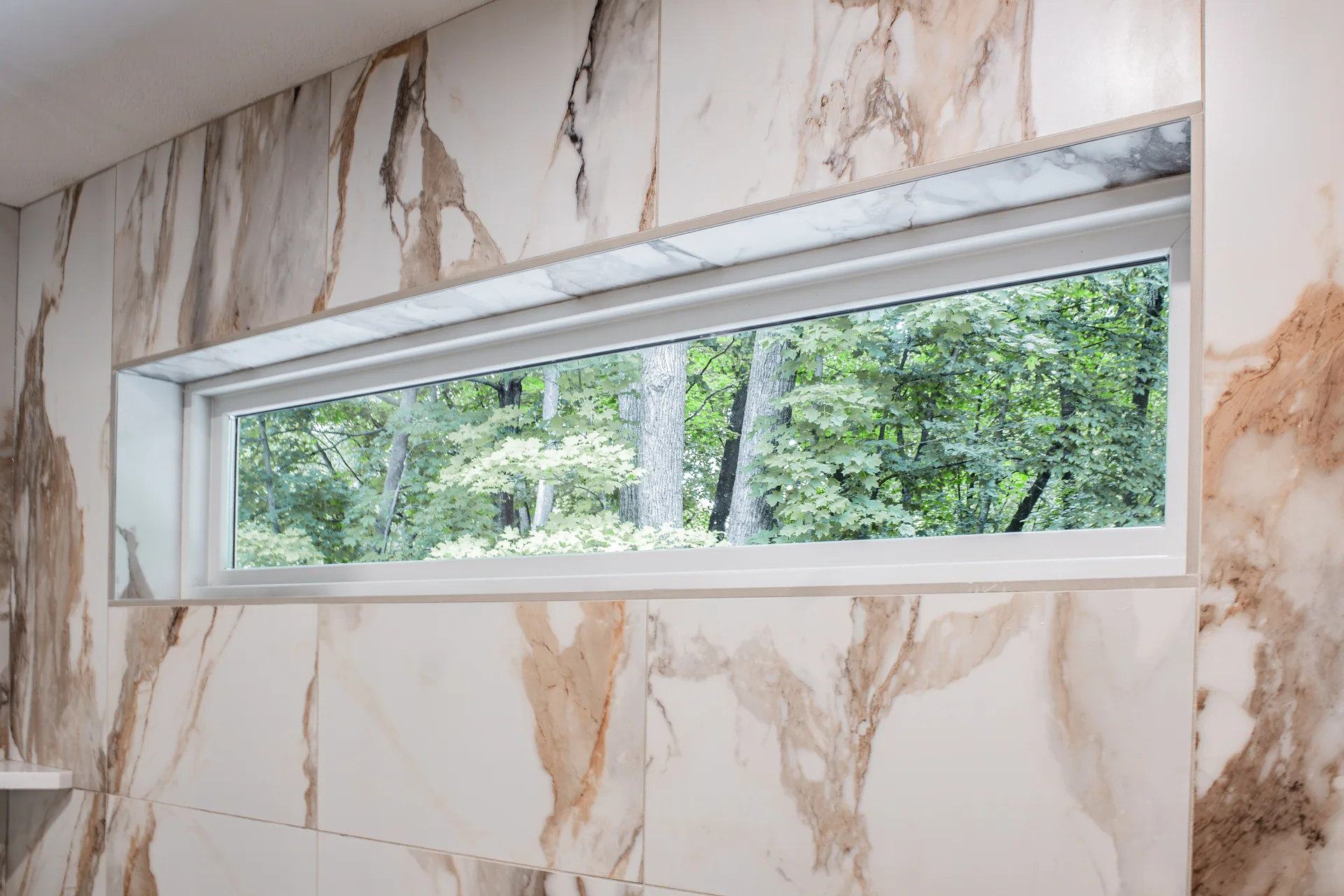 High shower window framed by patterned wall tile