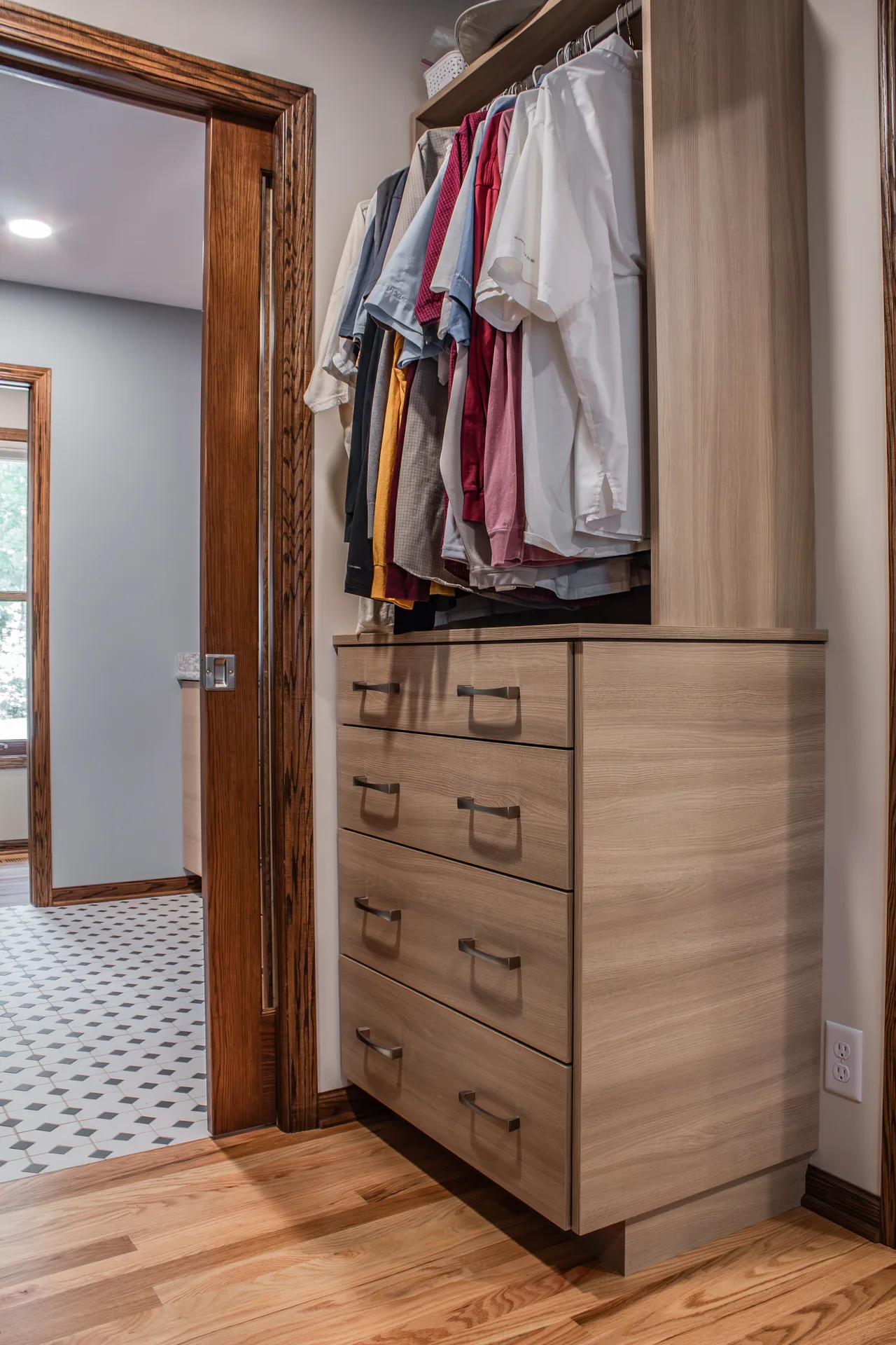 Closet drawers and hanging storage beside the bathroom