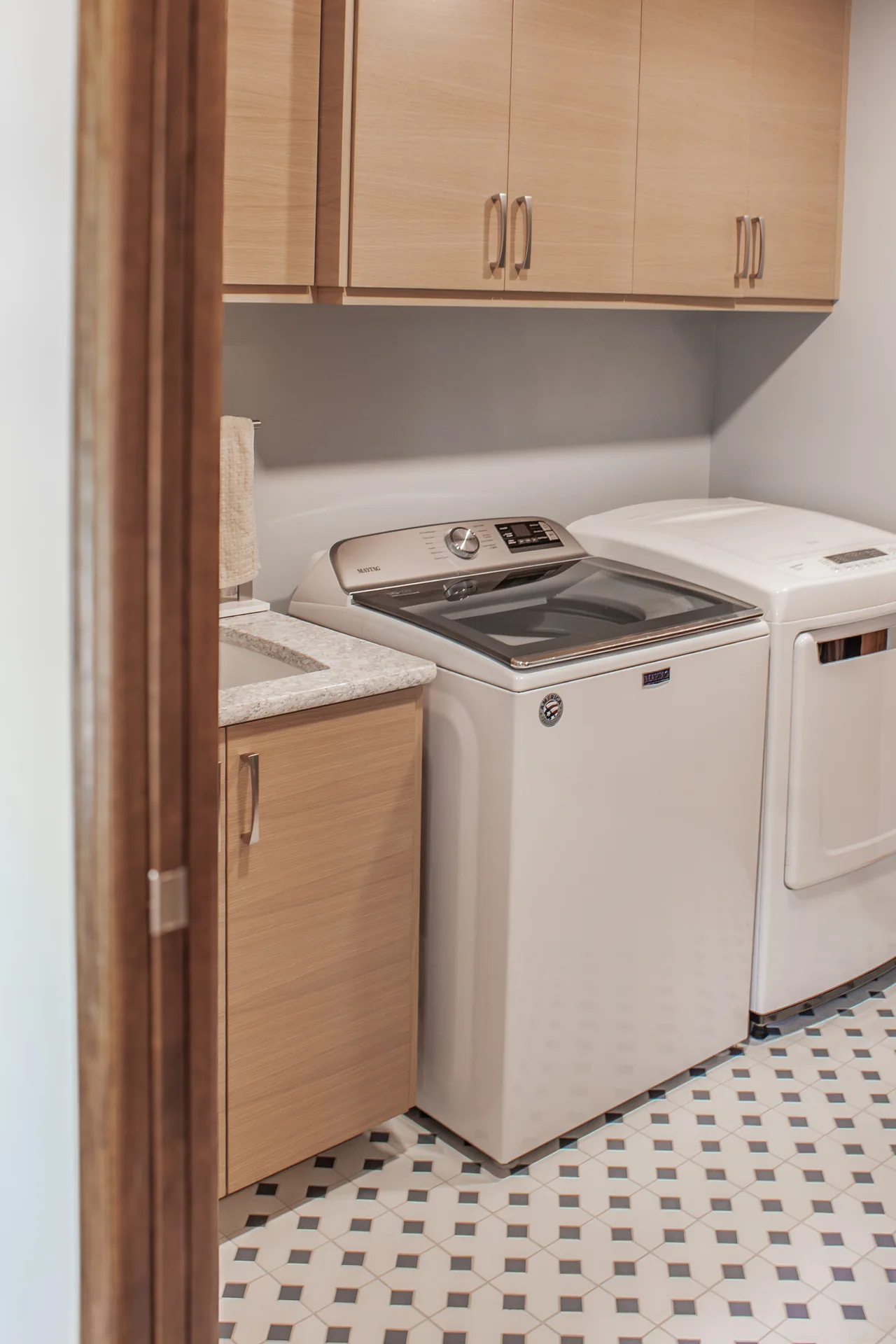 Laundry appliances beneath wood wall cabinets