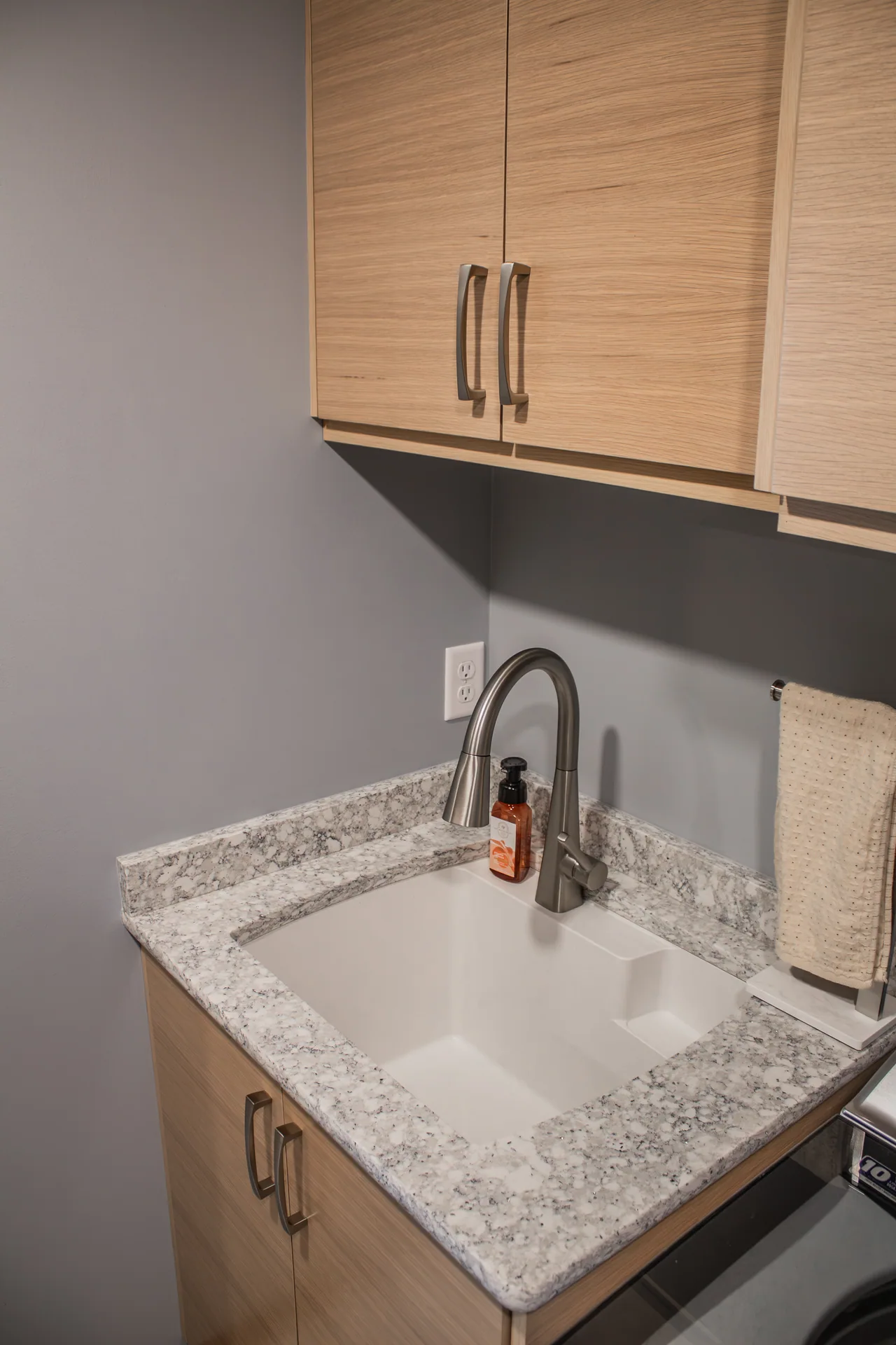 Laundry sink, countertop, and storage cabinets