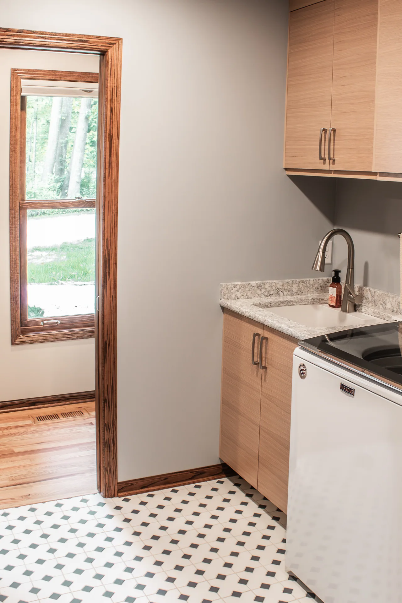 Laundry room with patterned floor and natural light
